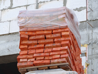 Red bricks stacked on wooden pallet
