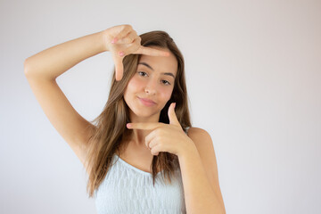 Fototapeta premium Pretty young girl making portrait gesture