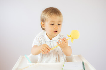 Blond baby playing with objects