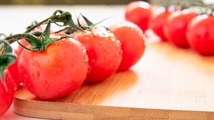 branch with cherry tomatoes on a white table, close-up