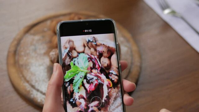 Close-up of hands taking pictures of Hong Kong waffles on a smartphone camera