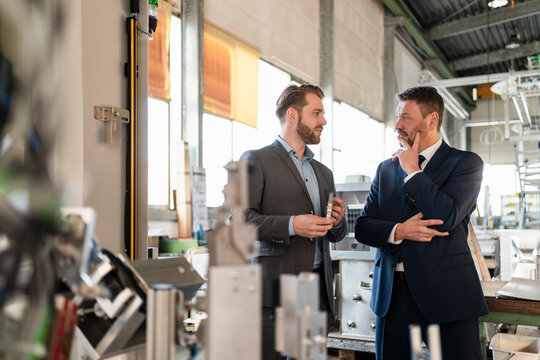 Two businessmen having a meeting in a factory