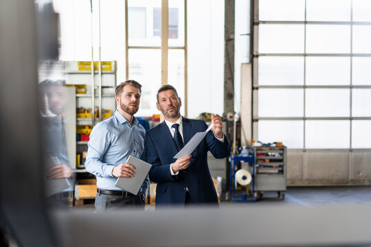 Two businessmen having a meeting in a factory