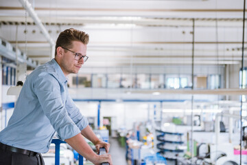 Businessman on upper floor overlooking factory