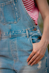 female hand in jeans overalls pocket