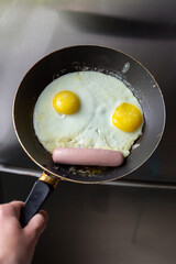 Fried eggs with sausage in a pan