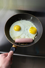 Fried eggs with sausage in a pan