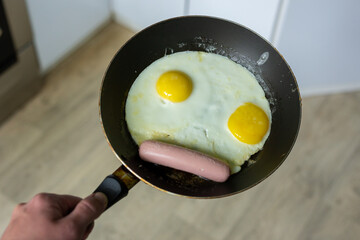 Fried eggs with sausage in a pan