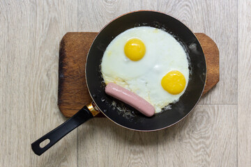 Fried eggs with sausage in a pan