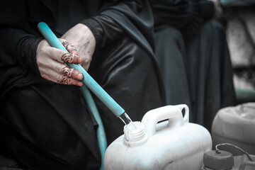 A Yemeni woman collects water due to the war and the stifling water crisis in the city of Taiz,...