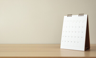 Calendar page close up on wood table with white wall background business planning appointment meeting concept