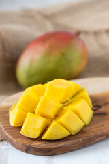 whole and cutted mango on wooden background