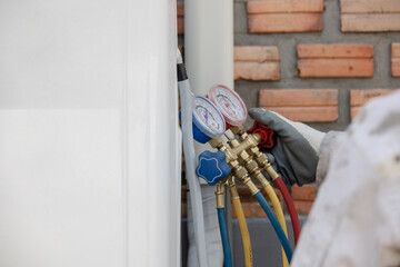 Air Conditioning Technician and A part of preparing to install new air conditioner. Technician vacuum pump evacuates and checking new air conditioner