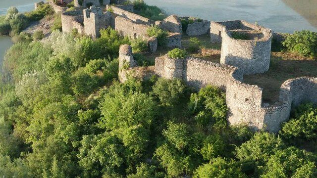 Medieval fortress on a lake island - ancient defense walls of a castle surrounded by lush green vegetation. Lesendro stronghold fortification on Lake Skadar in Montenegro.