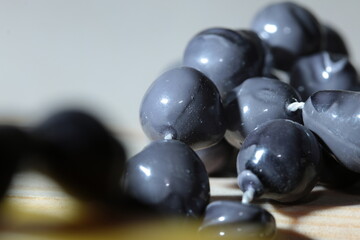 Cheap Dark Grey Plastic Beads, on a white thread,, close up Macro