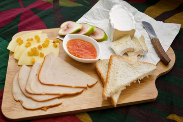Appetizers table with snacks. Brie cheese, ham, bread, jam. Option for Breakfast