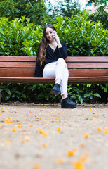 Beautiful young woman making a call in the park