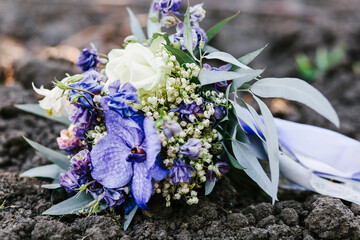 wedding bouquet of the bride in white and purple shades lying on the ground