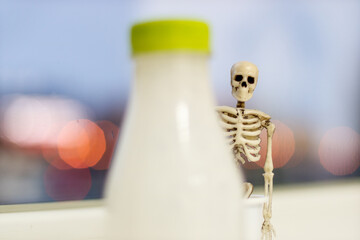 skeleton and a bottle of kefir out of focus. the harmfulness of dairy products and animal suffering