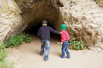 Obraz na płótnie Canvas Children explore the entrance to the cave