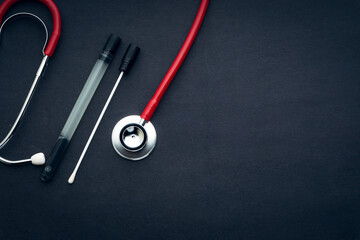 Medical swab and stethoscope closeup on black background. Health care and copy space concept