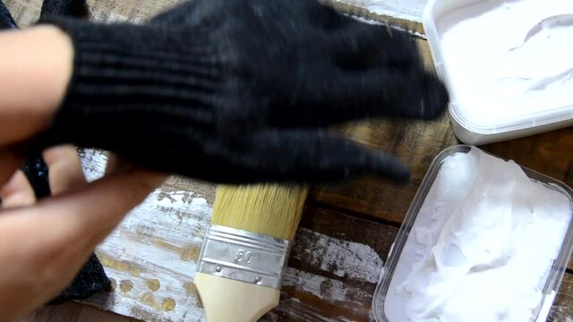 Hands of an old manual worker with wall plastering tools renovating house. Plasterer renovating outdoor walls and corners with spatula and plaster. Wall insulation. Construction finishing works - Imag