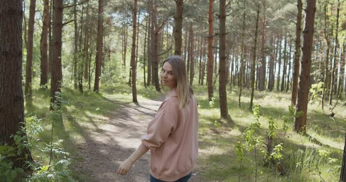 Young attractive woman walking smiling in a summer forest