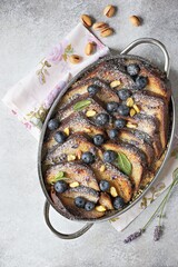 Bread pudding with vanilla sauce, blueberry and lavender flowers. Top view