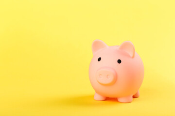 pink piggy bank on a yellow background. Concept of saving money or savings, investment.