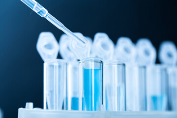 microbiological pipette in the genetic laboratory. study of a virus or vaccination. blue tinted.