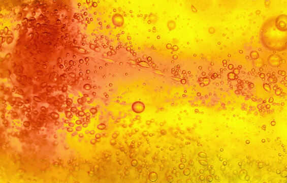 Abstract textured gel background. Yellow and orange liquid with bubbles.