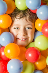 Fototapeta na wymiar Portrait of a boy with his face surrounded by colored balls.