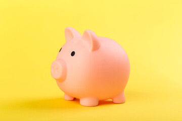 pink piggy bank on a yellow background. Concept of saving money or savings, investment.