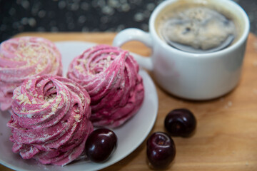 Marsmallows in plate with coffee and cherry.