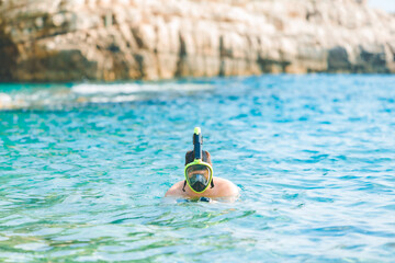 man swimming with snorkeling mask at blue azure sea water