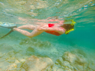 woman in red swimming suit underwater with snorkeling mask and flippers