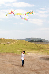 niño latino jugando volando papalote multicolor