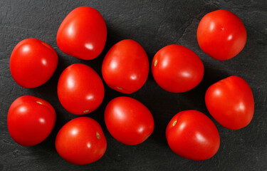 Top down view, dozen of mini tomatoes on black stone desk