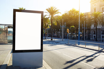 Blank billboard with copy space for your text message or content, outdoors advertising mock up, public information board on city road, flare sun light. Empty Lightbox on urban setting sidelines © BullRun