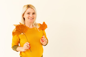 Young woman with autumn leaves in hand white background
