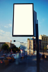 Fototapeta premium Blank billboard with copy space for your text message or content, public information board in the big town, advertising mock up empty banner in metropolitan city at beautiful sunny day, blur effect