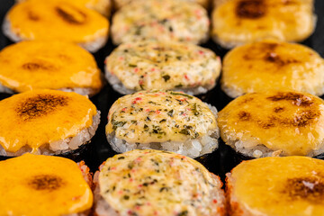 Set of baked sushi rolls with wasabi and ginger on a black background. Japanese oriental cuisine