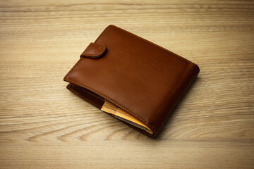 Wallet stuffed with Euro banknotes on the wooden backround