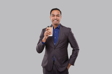 Businessman Holding Coffee To Go Cup Isolated. Indian Business man with Coffee Take Away Cup in Hands