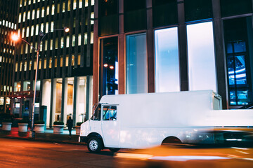 Truck of logistic shipping company on city road delivering goods for order quickly in time at...
