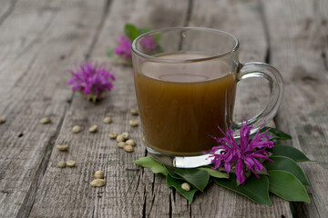 Coffee composition  with  glass  cup    of coffe with herb  and beans of coffe,   on rustic  wooden table