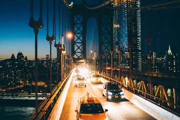 Foto auf Acrylglas New York TAXI Metropolitan traffic on Brooklyn bridge with vehicles shining with evening light, yellow cab taxis driving from Manhattan to another district, River crossings, Environmental impact reduction concept