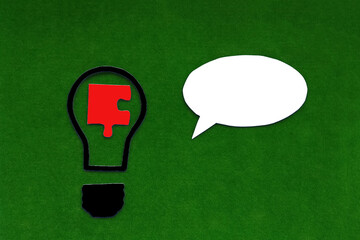 A light bulb, a piece of a puzzle, an oval for text on a green background. The concept of creativity, business ideas.
