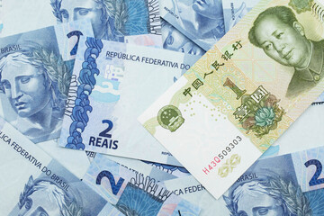 A close up image of a green, one Chinese yuan bank note, close up on a background of blue Brazilian...