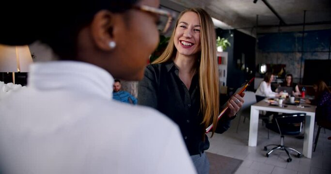 Business people at healthy workplace. Young positive African woman is greeted in loft multiethnic office slow motion.